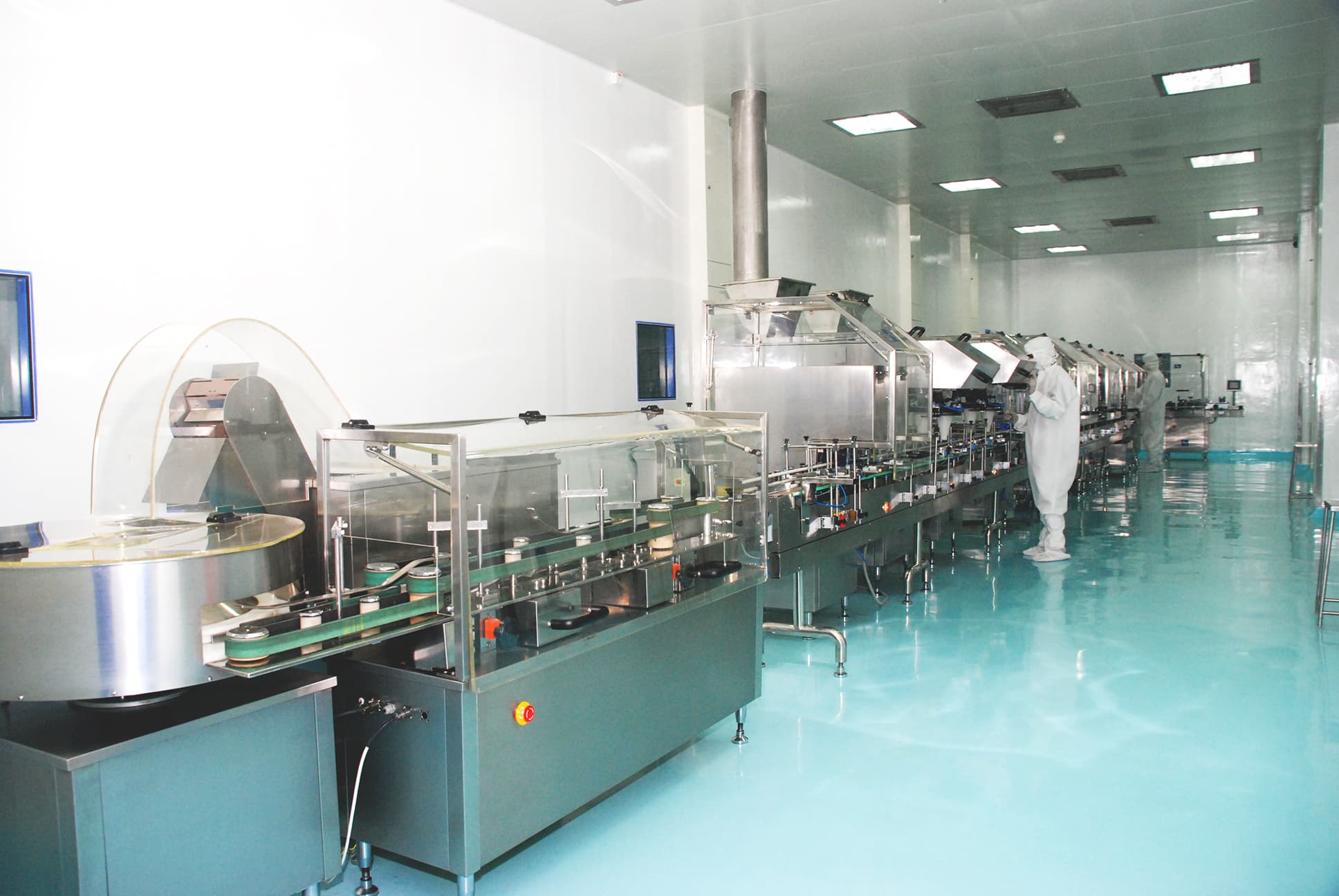 Gowned operators on a validated pharmaceutical production line inside a classified cleanroom