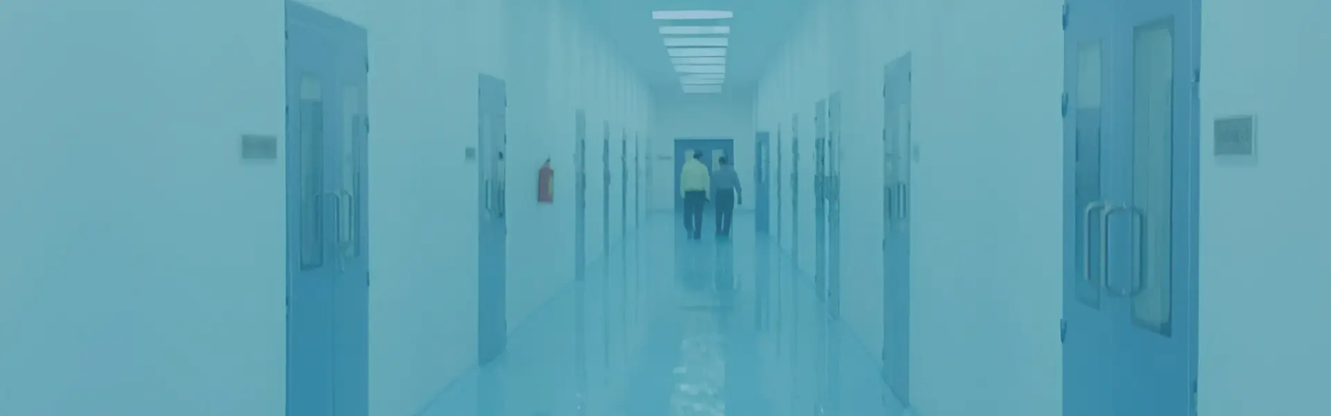 Long pharmaceutical cleanroom corridor with flush doors, seamless flooring and two engineers walking, Ajanta Pharma, Aurangabad