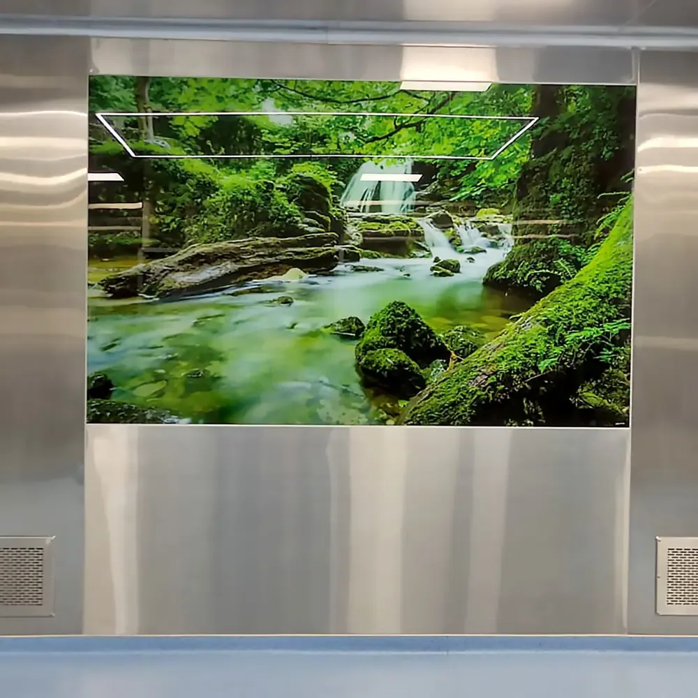 Stainless steel theatre wall with a backlit mural panel and low-level return grille