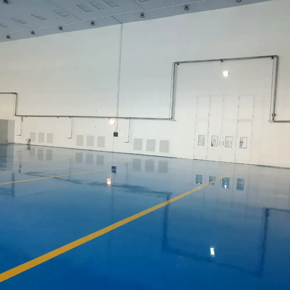 Corner of the assembly hall showing wall panels and yellow floor demarcation