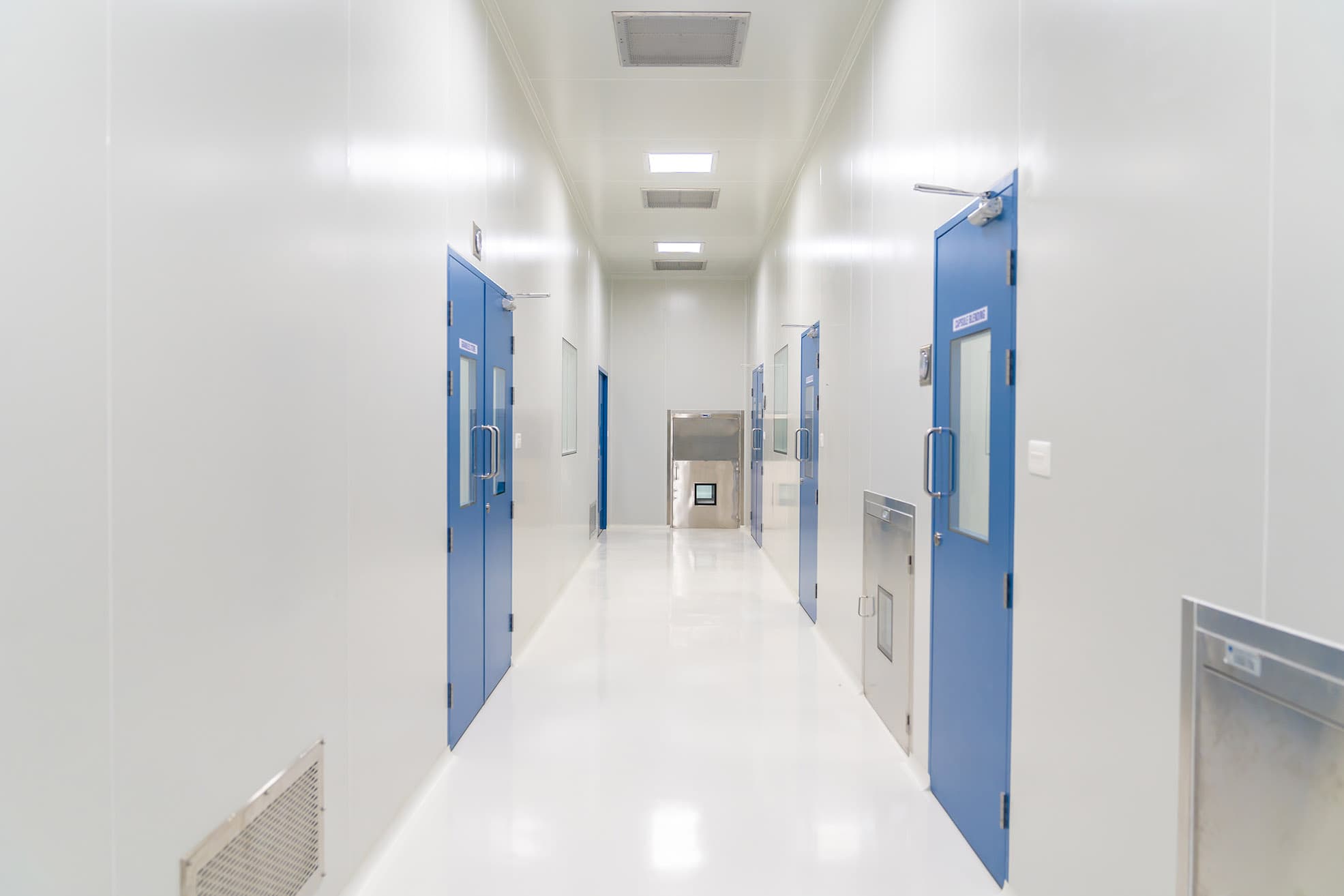 Hygienic cleanroom corridor with flush panels, coved floor junctions and washdown-compatible doors